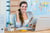 Pretty travel agent reading magazine in the office